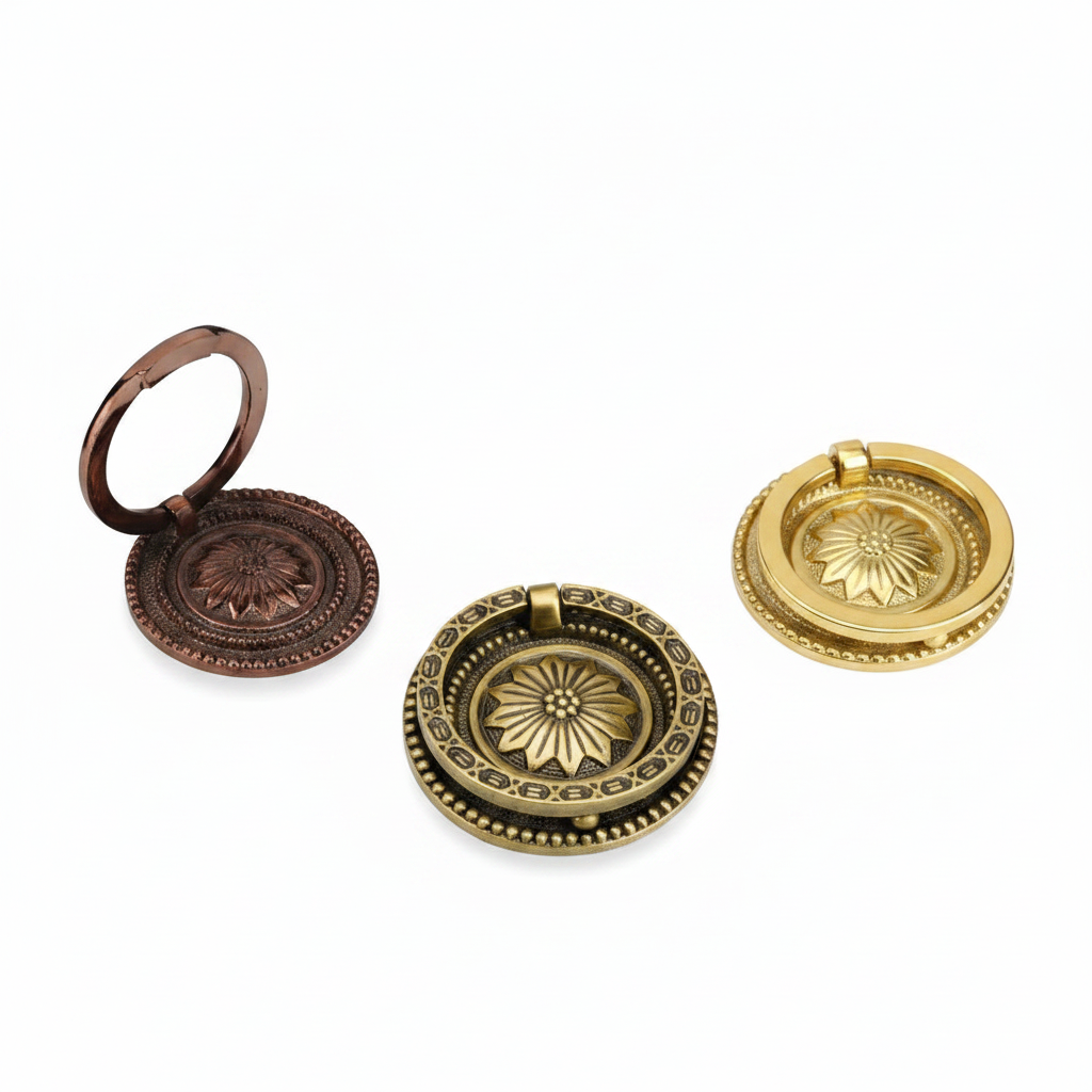 A set of three decorative round ring pull handles for cabinets and furniture, featuring a central embossed floral sunflower motif on an ornate backplate. The handles are shown in three premium finishes: rose gold, antique brass, and gold.