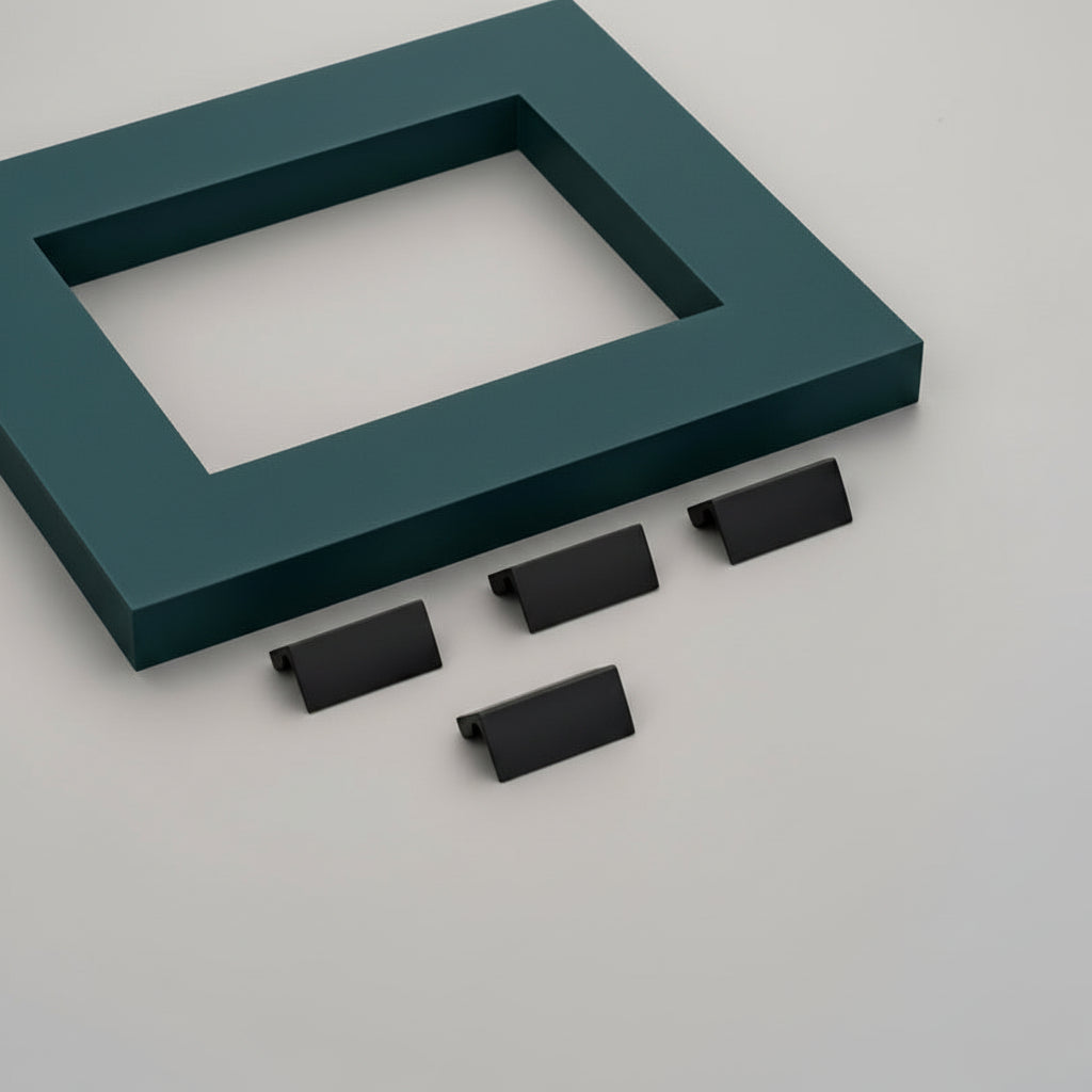 A set of four Creatick KB-43 minimalist edge pull handles in a sleek matte black finish. These modern, low-profile cabinet pulls feature a sharp angular design and are displayed on a grey surface next to a teal frame, perfect for contemporary kitchen cupboards and integrated drawer hardware.