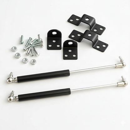 A complete 12-inch heavy-duty gas strut kit featuring two black hydraulic lift supports with polished silver rods. The professional hardware set includes four specialized black mounting brackets (two L-shaped and two bridge-style), along with a full set of installation screws and nuts. Designed for smooth, controlled lifting of heavy cabinet doors, automotive hoods, and storage lids.