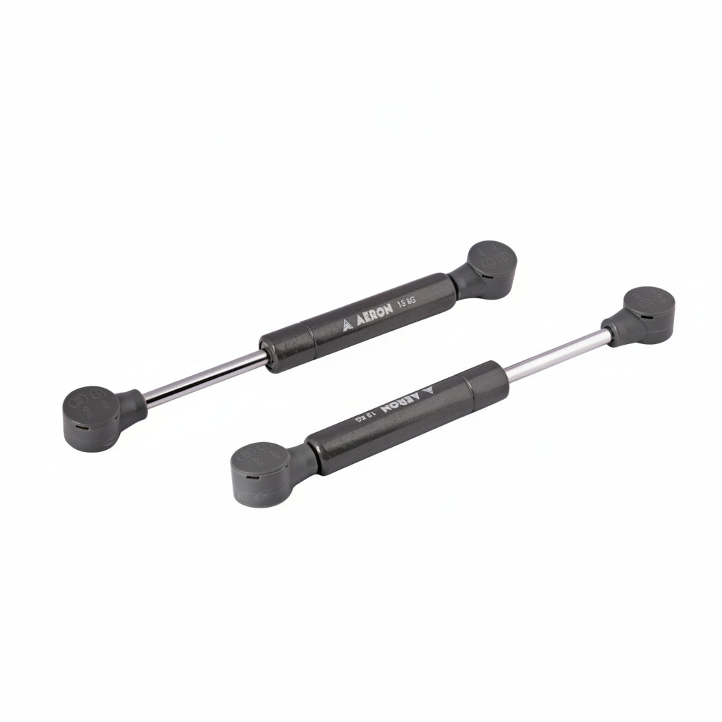 A pair of Aeron 6-inch hydraulic gas pumps in a durable charcoal grey finish, each featuring a 15kg load-bearing capacity. These compact pneumatic lift supports are equipped with reinforced ball joint connectors, specifically designed to provide high-pressure lift and smooth, controlled movement for heavy cabinet doors, specialized storage hatches, and compact furniture lid applications.