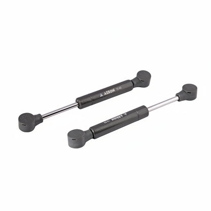 A pair of Aeron 6-inch hydraulic gas pumps in a durable charcoal grey finish, each featuring a 15kg load-bearing capacity. These compact pneumatic lift supports are equipped with reinforced ball joint connectors, specifically designed to provide high-pressure lift and smooth, controlled movement for heavy cabinet doors, specialized storage hatches, and compact furniture lid applications.