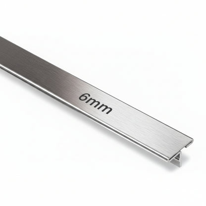 A high-precision 6mm T-shaped metal profile featuring a premium brushed stainless steel finish. This architectural trim is designed for decorative inlays in furniture, wall paneling transitions, and floor dividers, showcasing a clean shadowless aesthetic for modern interior design.