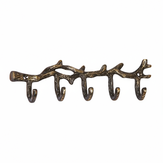 A decorative wall hook rack designed to resemble a natural tree branch with textured bark details in an antique brass finish. The rack features five integrated curved hooks and two pre-drilled mounting holes for secure installation in entryways or mudrooms.