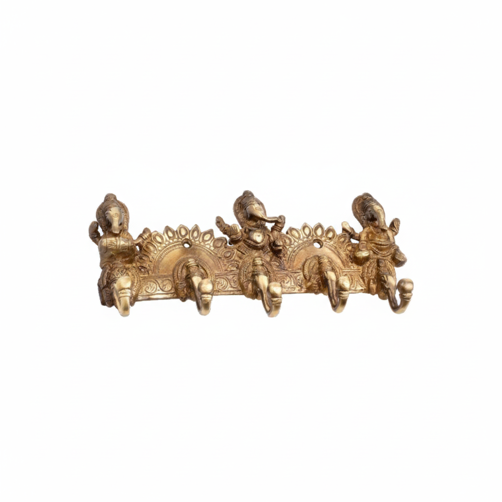 An antique brass wall hook rack featuring three detailed figures of Lord Ganesha in various poses, set against an ornate sunburst-style backplate with five curved hooks for organizing keys,or light accessories.