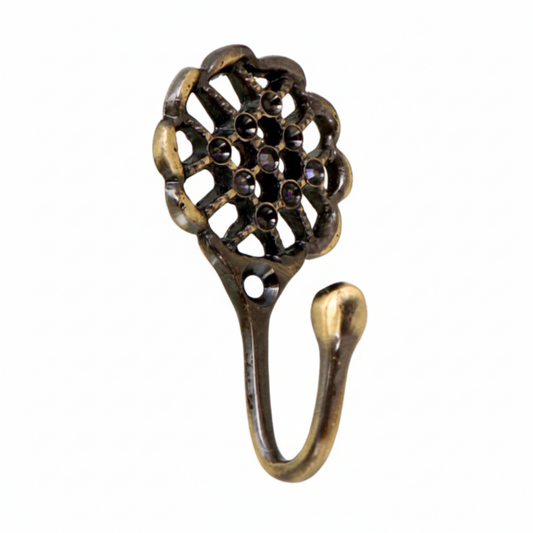 A decorative wall hook featuring an ornate circular floral backplate with a lattice design and embedded dark crystals in an antique brass finish. The vintage-style hardware includes a mounting hole and a smooth curved hook for hanging jewelry, keys, or lightweight accessories.