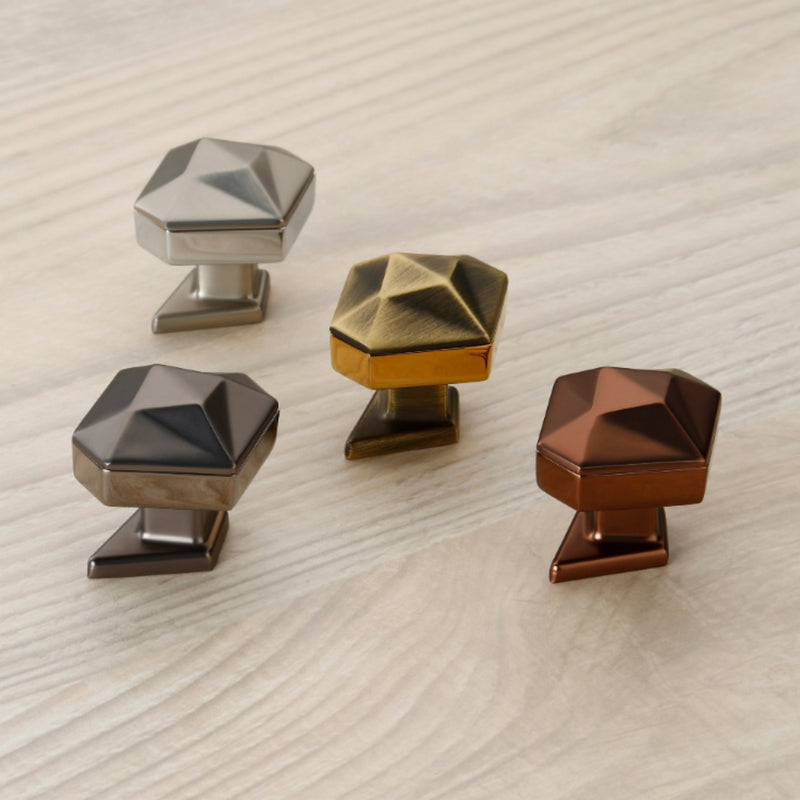 Four geometrically shaped metal knobs on a textured surface