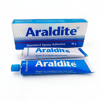 A 90g retail pack of Araldite Standard Epoxy Adhesive featuring two collapsible tubes—one white and one blue—representing the resin and hardener. The packaging highlights its high bond strength and suitability for various surfaces when roughened, dried, and degreased.