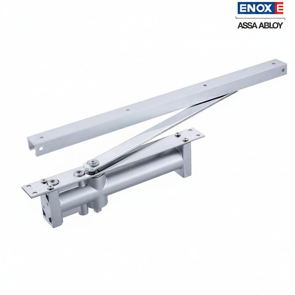 An ENOX (Assa Abloy) concealed overhead hydraulic door closer with a premium satin silver finish. The unit features a high-precision guide rail and sliding arm assembly designed for "invisible" installation within the door leaf or frame. This architectural-grade hardware provides smooth, adjustable hydraulic control, ideal for minimalist modern interiors in luxury residential and commercial office spaces.