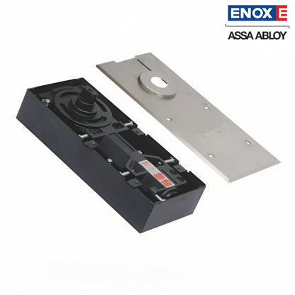 A high-performance ENOX (Assa Abloy) hydraulic floor spring assembly featuring a heavy-duty black cement box housing and a matching satin stainless steel cover plate. This architectural floor-mounted closer is designed for recessed installation, providing invisible and durable door control for frameless glass, timber, or metal doors. It includes integrated valves for adjustable closing and latching speeds, ideal for modern commercial entrances and high-end residential interiors.