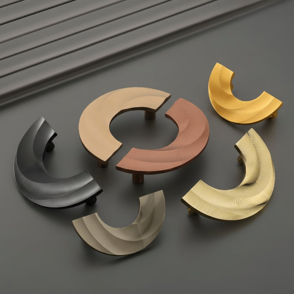 A collection of Creatick DH-105 modern cabinet handles featuring a unique, abstract curved wave design with a fine-lined texture. These artistic sculptural furniture pulls are shown in matte black, champagne, rose gold, and polished gold finishes—perfect for high-end kitchen cabinetry, designer wardrobes, and contemporary interior hardware.