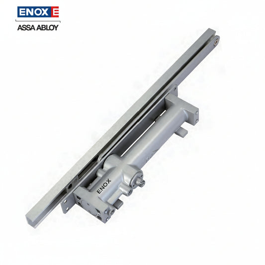 An ENOX (Assa Abloy) concealed hydraulic door closer with a sleek satin silver finish and integrated guide rail track. This high-performance architectural hardware is designed for hidden installation within the door or frame, providing smooth, adjustable closing and latching speeds for modern commercial and luxury residential doors.