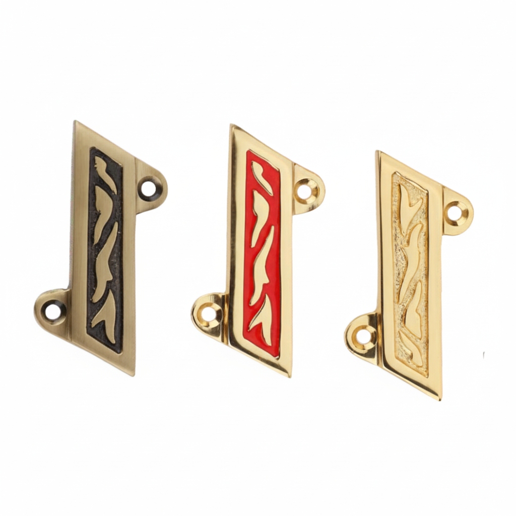 Three Fab 0210 Shree symbols for wall mounting, featuring antique brass with black inlay, polished gold with red enamel (Red Mina), and a textured gold finish, all with intricate vine carvings and integrated mounting holes.
