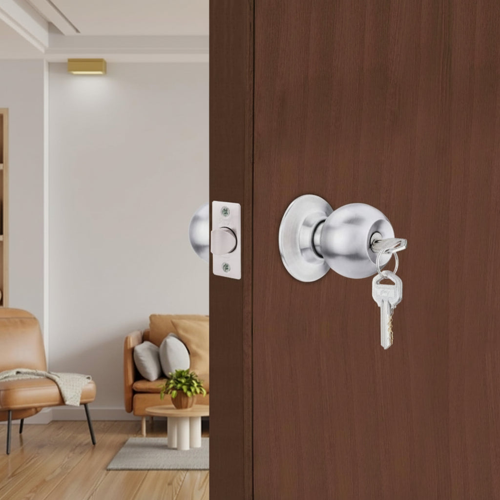 Godrej Classic cylindrical door lock with a brushed satin finish and keyed entry, installed on a rich wood-grain door within a modern, brightly lit residential living room interior.