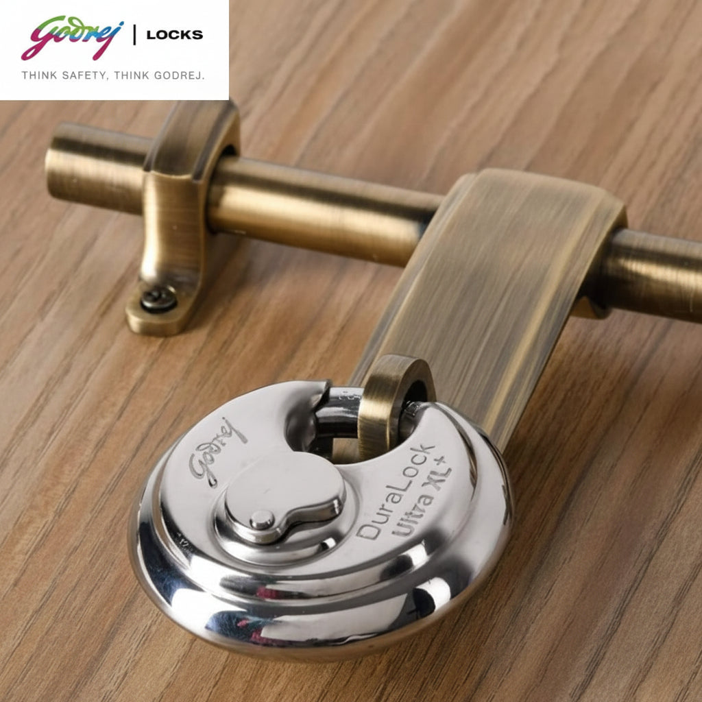 Godrej Duralock Ultra XL+ high-security silver disc padlock securely installed on an antique brass finish door latch and aldrop system, demonstrating its snug fit and hardened shackle protection.