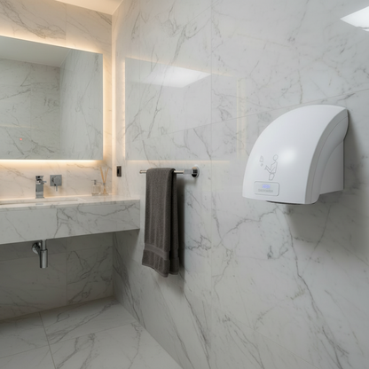Lifestyle view of a Grafiqe white automatic hand dryer with Eco Sensor technology, mounted on a white marble wall in a luxury bathroom featuring a floating marble vanity, backlit mirror, and modern chrome fixtures.