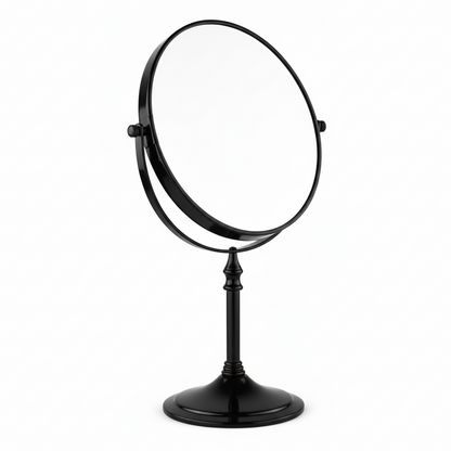 Grafiqe freestanding circular pedestal mirror in a sleek matte black finish, featuring a 360-degree double-sided swivel head for standard and magnified viewing on a stable weighted base.