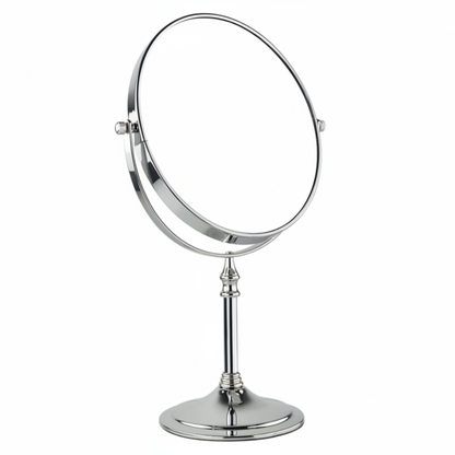 Grafiqe circular pedestal tabletop mirror in a brilliant chrome finish, featuring a 360-degree double-sided swivel head for standard and magnified views on a slender stem and a stable weighted base.
