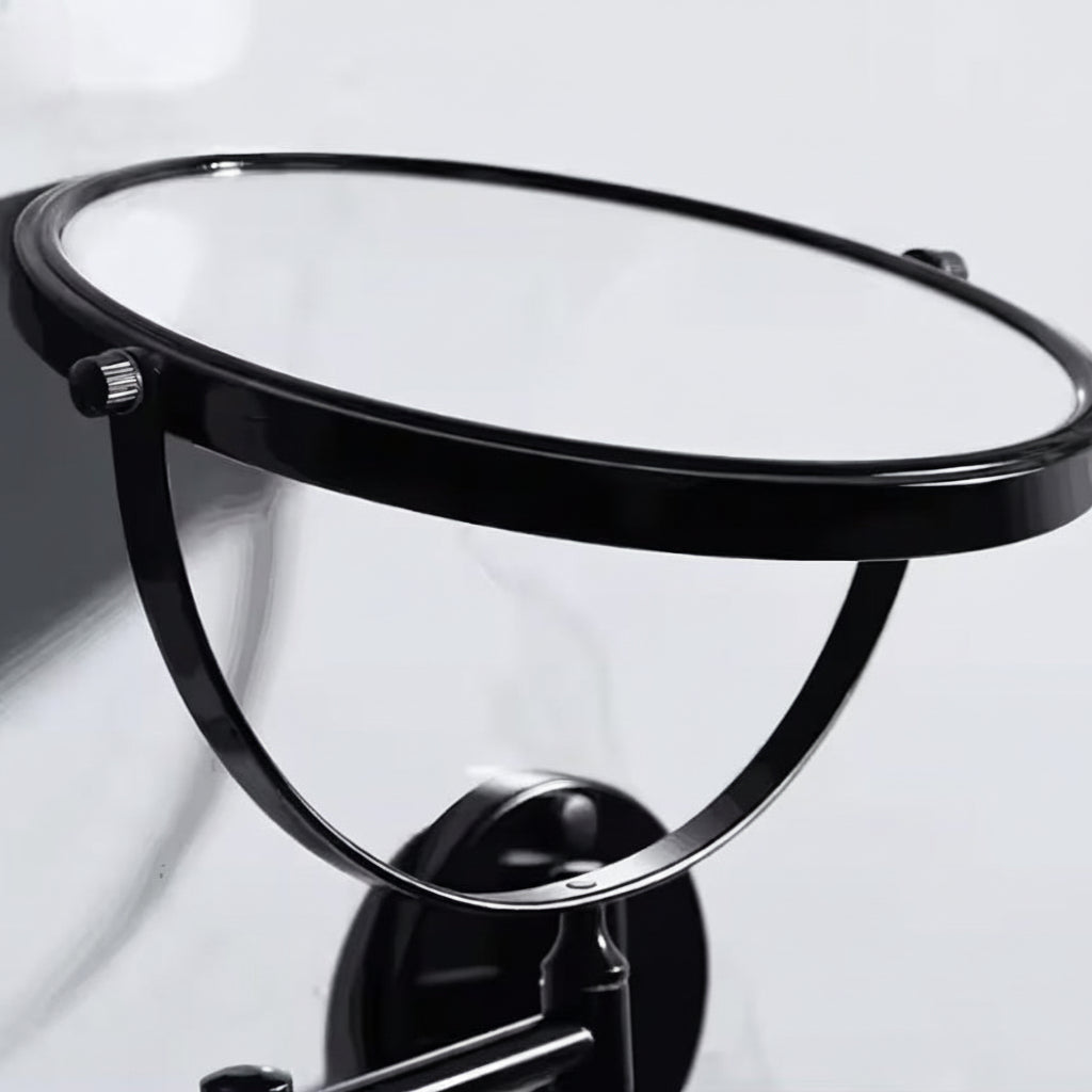 Close-up of the Grafiqe circular vanity mirror in a black finish, showcasing the 360-degree vertical swivel pivot and the high-clarity glass set within a sleek, minimalist metallic frame.