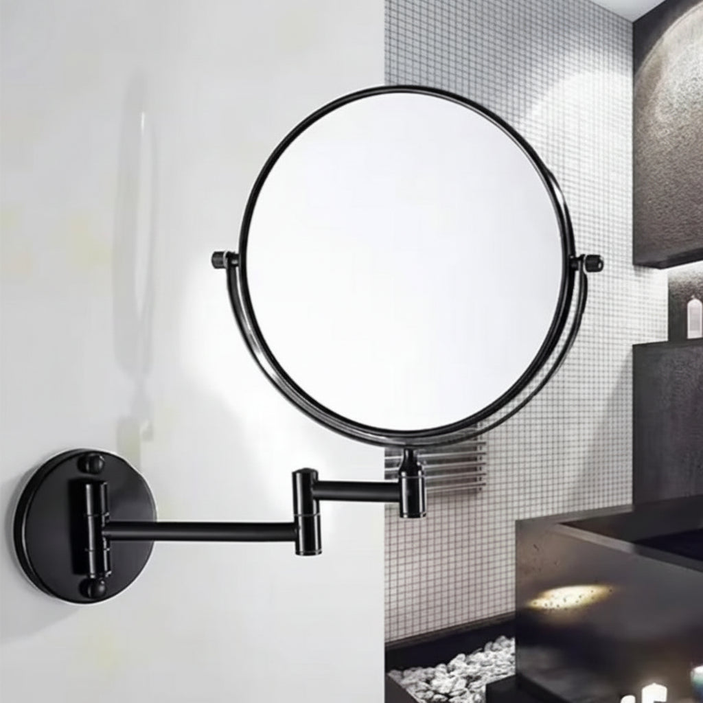 Lifestyle view of a Grafiqe black circular vanity mirror installed on a clean white wall, featuring a telescopic double-swivel arm and a 360-degree rotating head, positioned next to a modern dark-toned bathroom vanity.