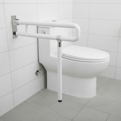 Lifestyle view of a Grafiqe white folding grab bar with a vertical floor support leg installed next to a modern white toilet on a gray tiled floor, featuring a space-saving flip-up design and anti-slip textured grip for elderly safety.