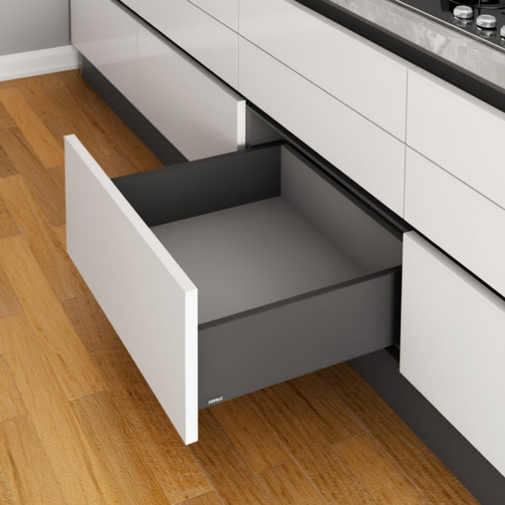 An open high-capacity Hafele deep slim double-wall kitchen drawer featuring a matte anthracite grey finish. The drawer is integrated into a modern white handle-less cabinet system under a marble countertop, showcasing premium German-engineered hardware for large kitchen storage and organization.