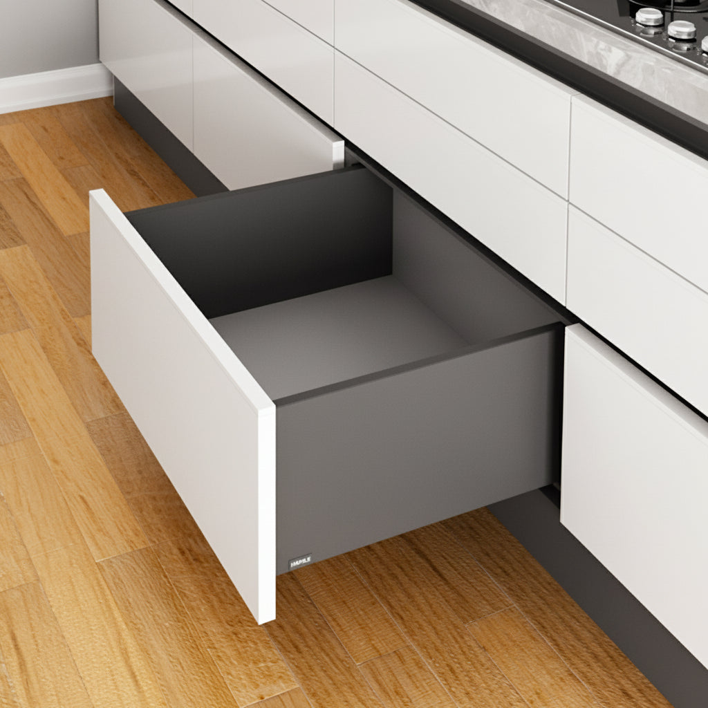An open high-capacity Hafele deep slim double-wall kitchen drawer featuring a matte anthracite grey finish. The drawer is integrated into a modern white handle-less cabinet system under a marble countertop, showcasing premium German-engineered hardware for large kitchen storage and organization.