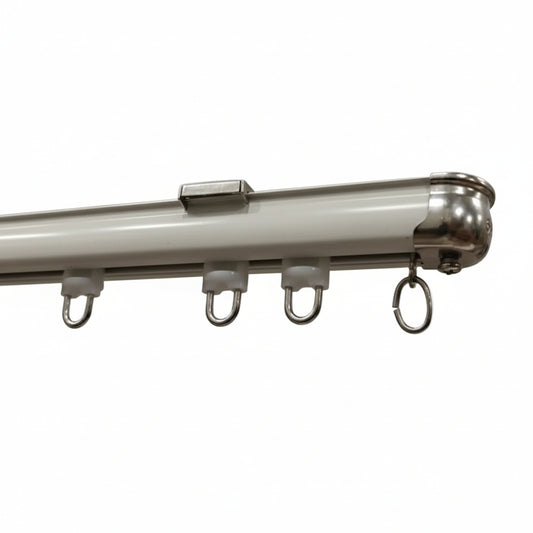 A professional-grade white powder-coated aluminum curtain track featuring high-quality silent sliding gliders and a polished stainless steel end cap. The image highlights the heavy-duty rail profile and durable metal components designed for smooth drapery operation in modern residential and commercial interiors.