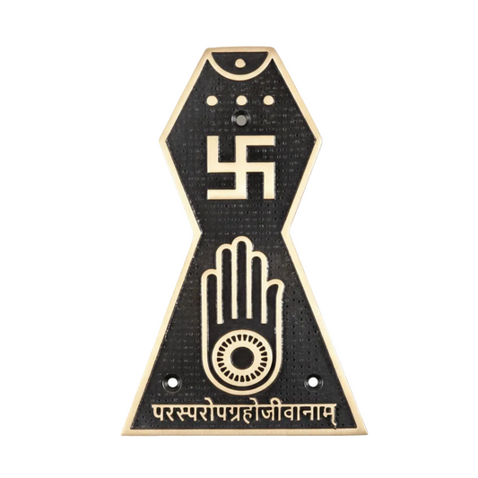 A Jain Prateek Chinha wall-mounted symbol in antique brass with a black textured finish, featuring the Swastika, the Ahimsa hand with the wheel of Dharma, and the sacred inscription 'Parasparopagraho Jivanam' at the base.