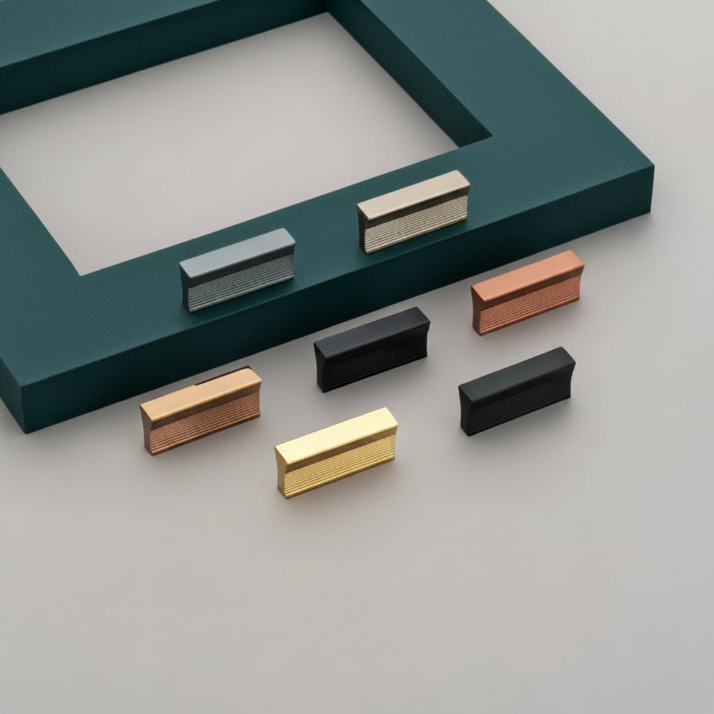 A display of Creatick KB-18 modern rectangular cabinet knobs featuring a sophisticated fine-ribbed texture on the front face. The collection is shown in a premium palette of finishes including matte black, rose gold, satin nickel, and polished gold. These sleek, minimalist hardware pieces are designed to provide a contemporary aesthetic for high-end kitchen cabinets, designer wardrobes, and luxury office furniture.