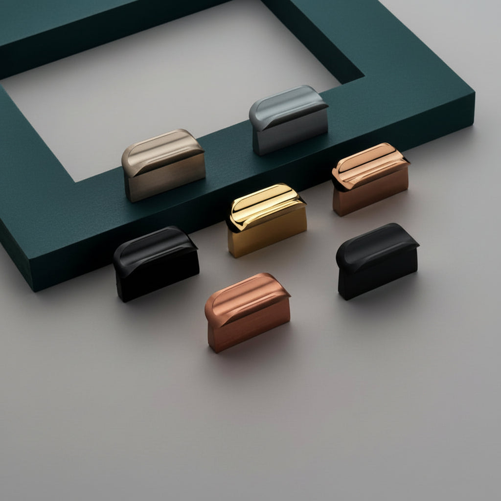 A variety of Creatick KB-41 modern rectangular cabinet knobs featuring a unique curved top profile. The collection is shown in elegant finishes including matte black, polished gold, rose gold, and brushed satin gray, displayed against a minimalist gray background with a teal accent frame for luxury furniture and kitchen hardware inspiration.