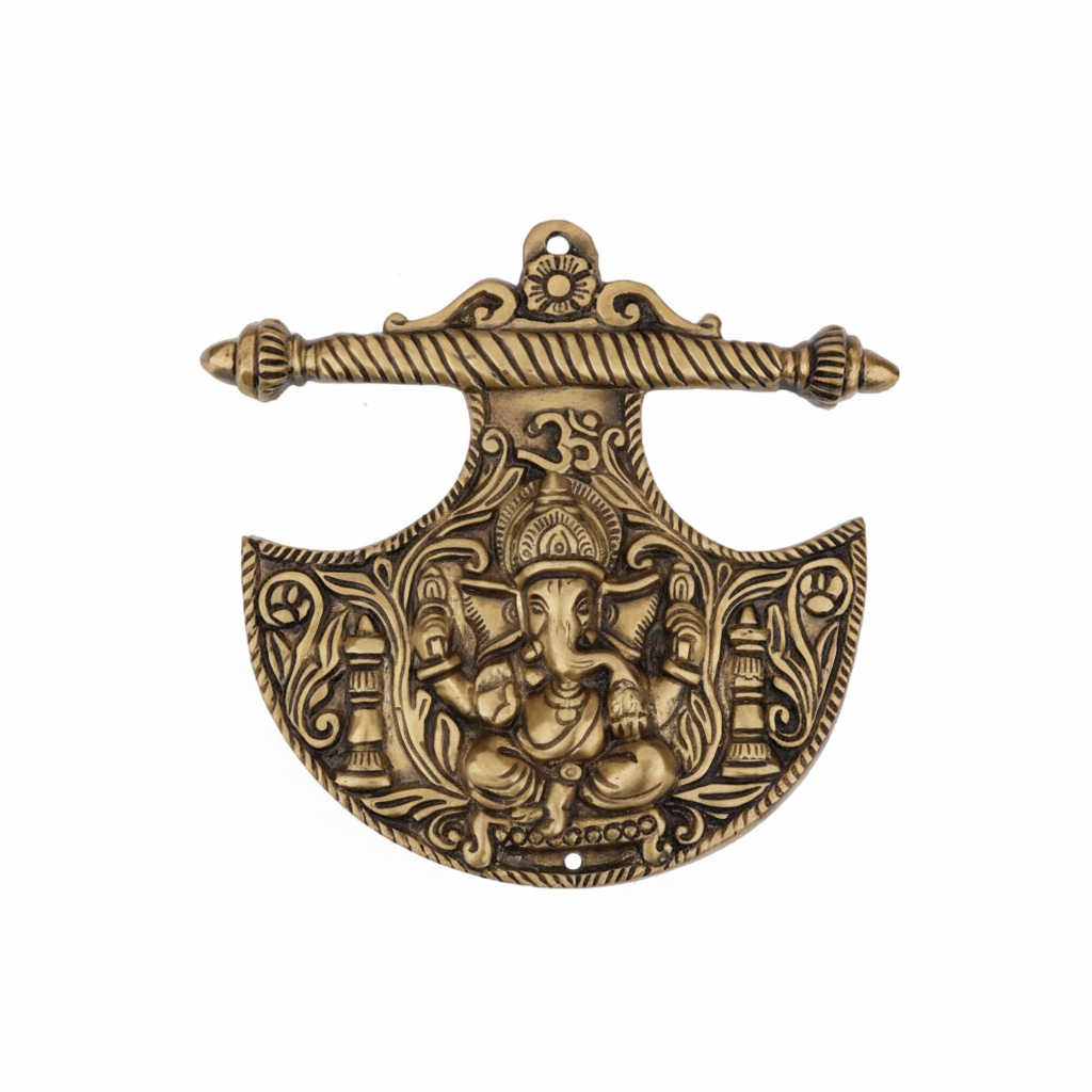 An antique brass wall-hanging accent in the shape of a Parashu (axe) featuring a central Lord Ganesha icon, a sacred Om symbol, and intricate floral carvings, designed for home temple decoration or Vastu protection at the main entrance.