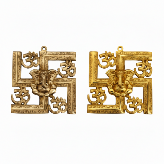 Two decorative Hindu wall accents featuring a central Lord Ganesha icon integrated into a Swastika frame with Om symbols at the corners, shown in antique brass and polished gold finishes for pooja room or home entrance decoration.